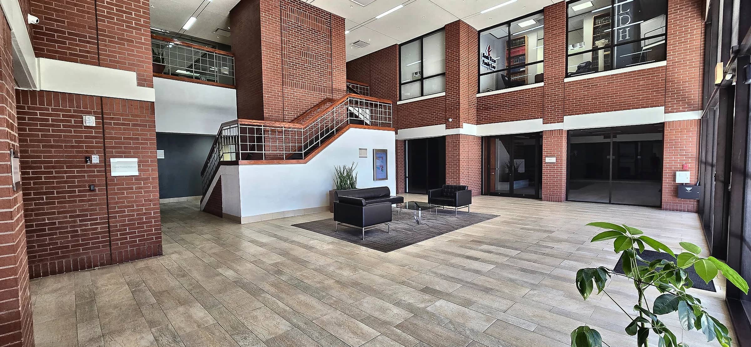 Two-story lobby with brick columns, an open staircase and lounge seating
